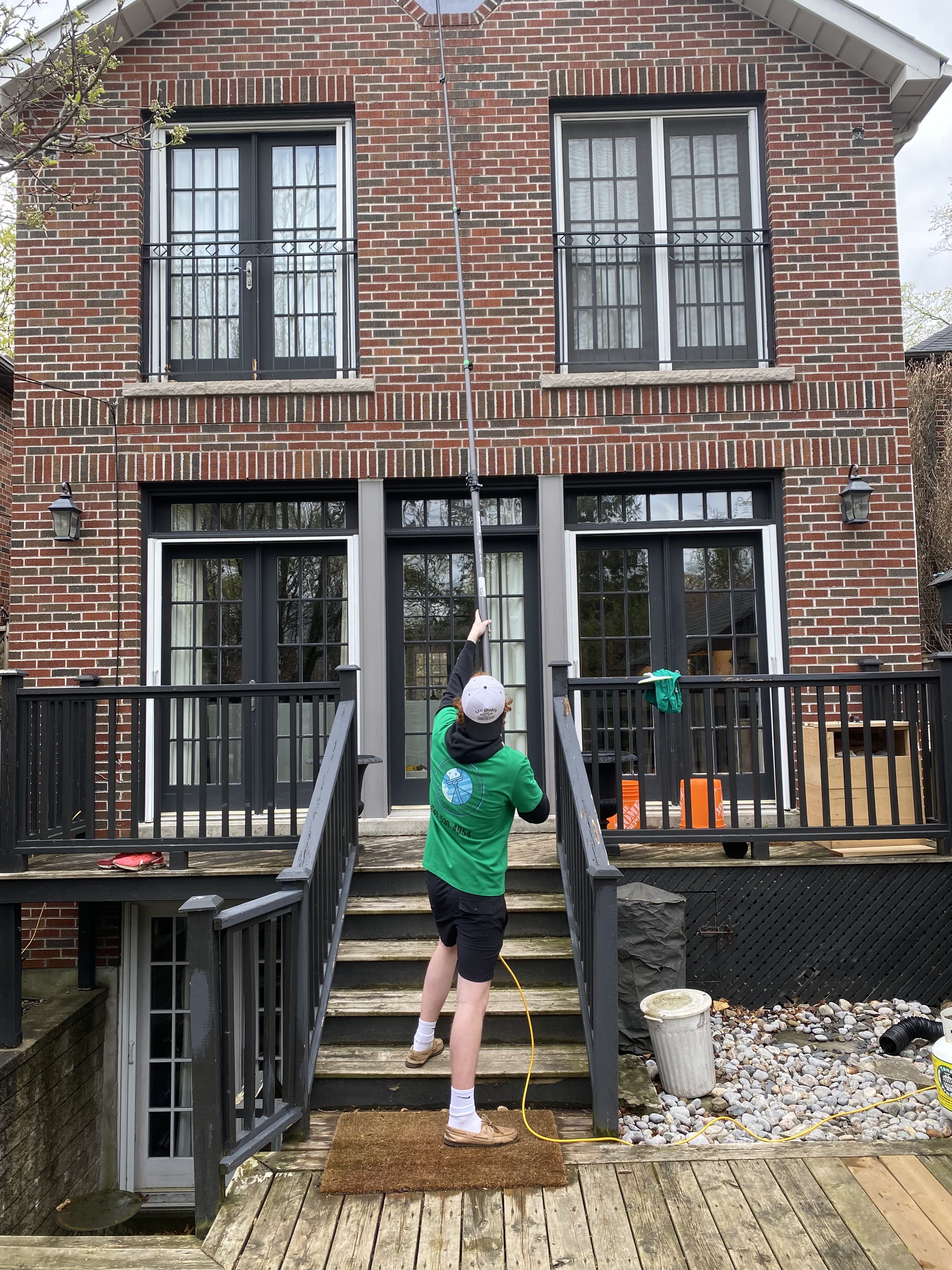 Alex Peters and Chris Kedwell cleaning windows on a Toronto home